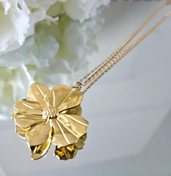 Necklace with its large gold-plated brass flower on a grained chain