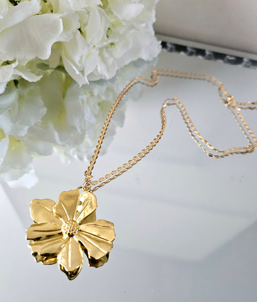 Necklace with its large gold-plated brass flower on a grained chain