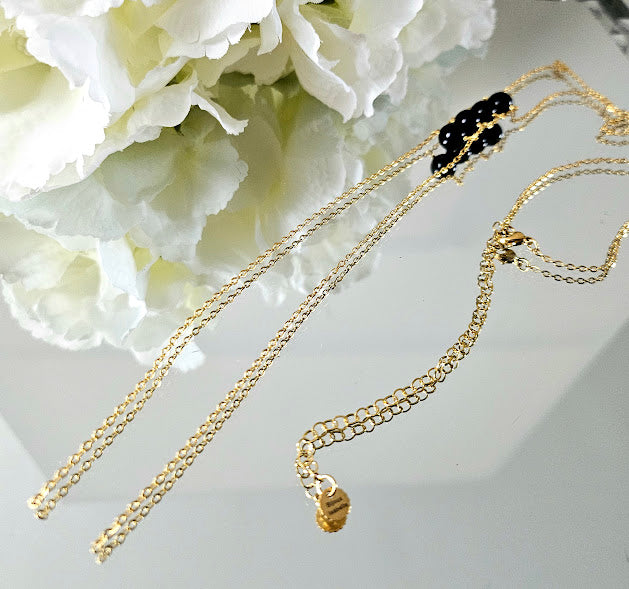 Collier oniris avec ses perles en onyx et ses chaînes en acier plaqué or