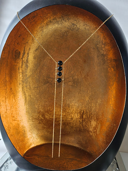 Collier oniris avec ses perles en onyx et ses chaînes en acier plaqué or